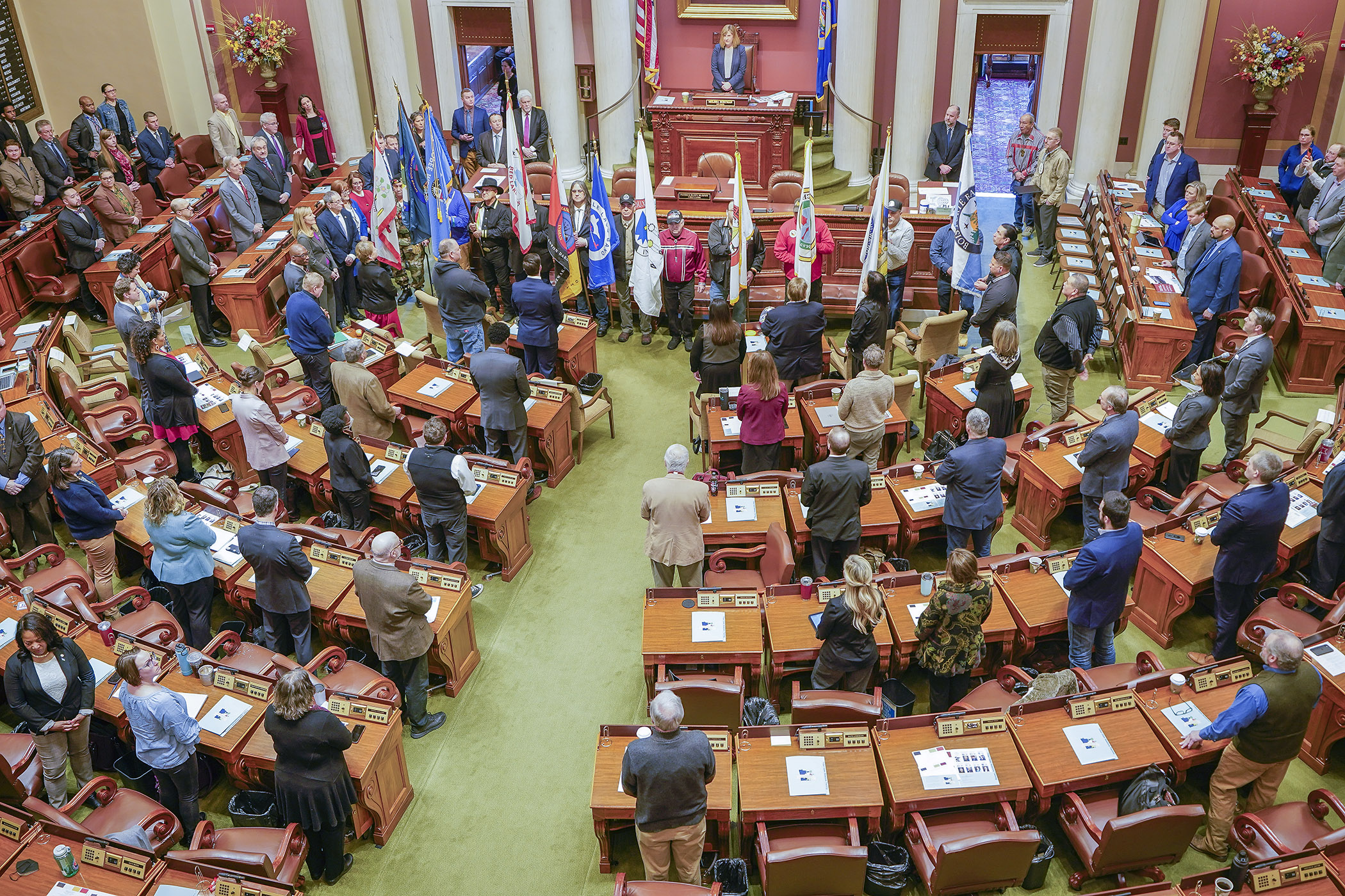 Tribal flagbearers surround the rostrum after a procession into the House Chamber to open Sovereignty Day at the Capitol March 13. (Photo by Andrew VonBank)